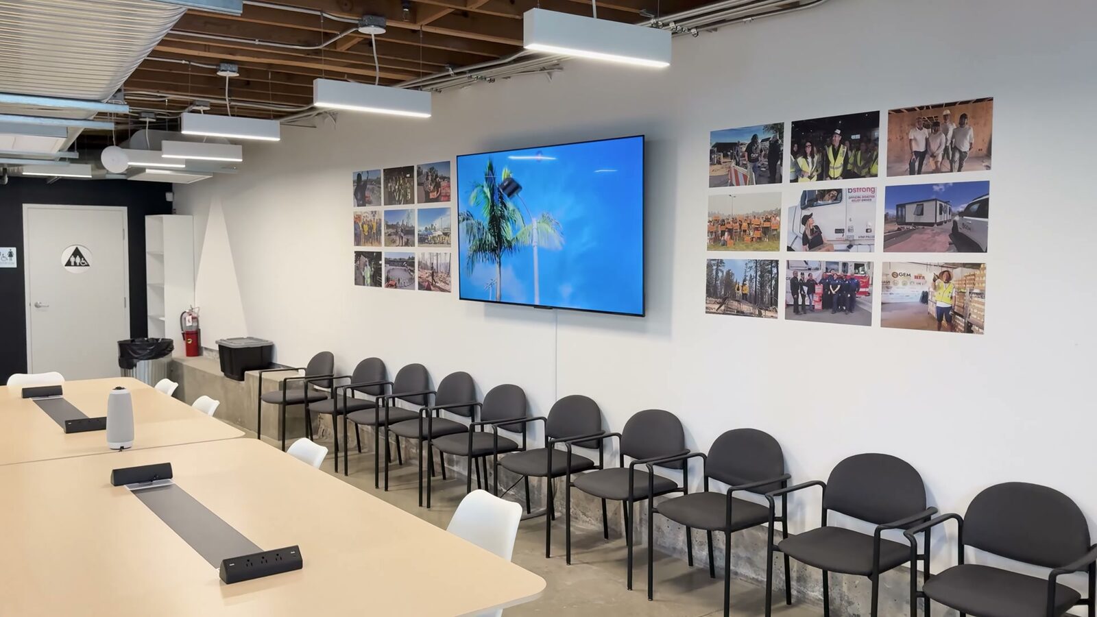 The Pali Hub's meeting room: a long table, rows of chairs, and a wall of photographs from the recovery